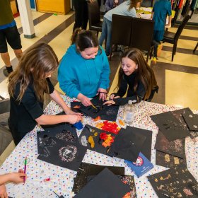 Photo of young people create art around a table